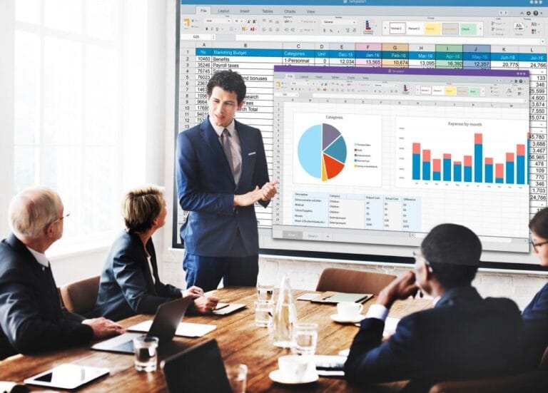 Consultoria de gestão empresarial com apresentação de dados financeiros em projeções de gráficos, com profissionais atentos ao especialista.