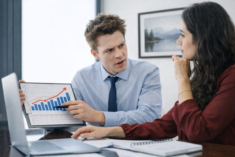 Homem apresenta gráfico de crescimento durante reunião de consultoria e gestão em situações de crise em ambiente corporativo.
